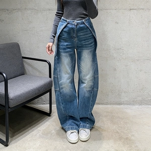 Dettaglio dei jeans a vita alta a gamba larga con tasche cargo decostruite