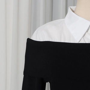 Dettaglio dell'elegante maglione nero in maglia con colletto bianco a contrasto e spalle scoperte