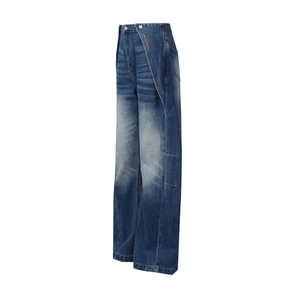 Dettaglio di jeans a gamba larga a vita alta con vita asimmetrica e ricamo in giallo