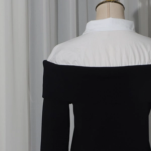 Dettaglio del top a spalle scoperte con colletto a camicia bianco e maglia nera a contrasto