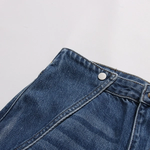 Dettaglio ravvicinato della vita in denim blu scuro con bottone argento e cuciture a contrasto