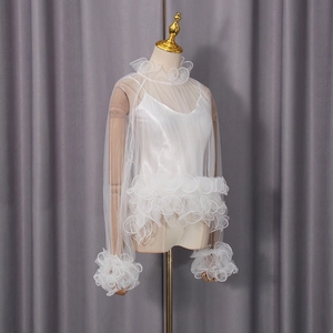 Detailed view of white mesh top featuring tiered ruffle sleeves and a silky camisole
