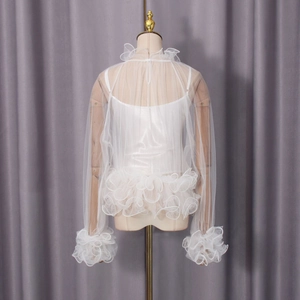 Detail of white mesh blouse with layered ruffles and stand-up collar and inner camisole