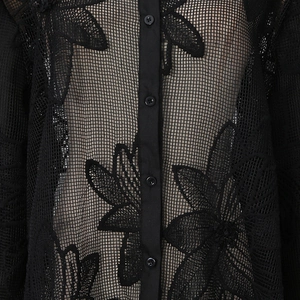 Détail de chemise en résille noire avec broderie florale et boutons assortis