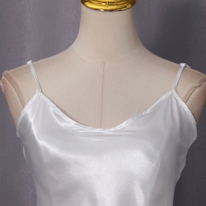 Detailed close-up of white satin camisole with thin straps and elegant curved neckline