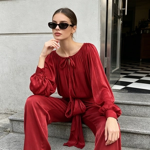 Close-up of red silk satin two-piece set featuring lace-up collar and elegant bow detail