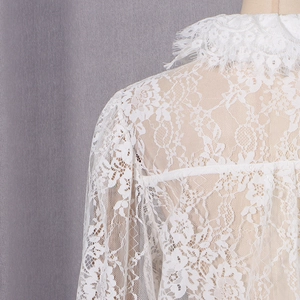 Détail de la dentelle florale blanche et de l'encolure festonnée du chemisier français