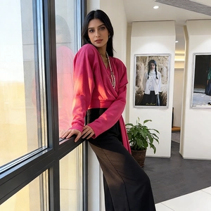 Detail of fuchsia wrap top with a deep V-neckline and elegant flowing fabric design
