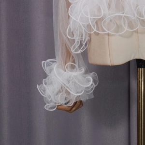 Detail view of white layered mesh ruffles and pleated organza on high-end women's shirt