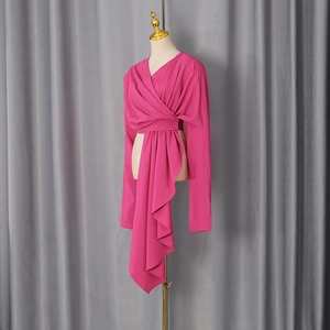 Detail view of the rose red cross-wrap V-neck top with an asymmetrical draped hemline