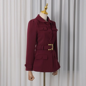 Detail view of burgundy fitted blazer with single-breasted buttons and gold belt buckle
