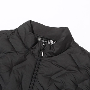 Detail of black quilted jacket featuring stand collar, metal zipper, and thermal lining