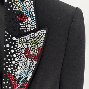 Close-up of luxury black blazer lapel featuring multi-colored rhinestone embroidery