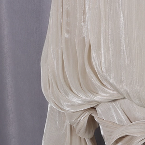 Close-up of elegant pleated champagne satin blouse with luxury metallic luster fabric