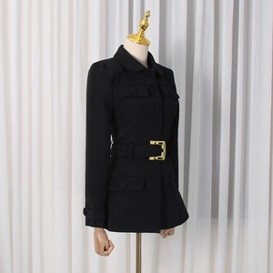 Detailed shot of black slim-fit blazer with chic golden buckle belt and pocket accents