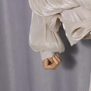 Detailed macro view of beige pleated satin fabric with elegant pearlescent texture