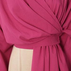 Detail of cross V-neck berry blouse with fabric covered buttons and wrap waist design