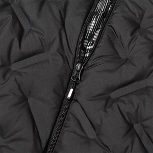 Detailed macro view of black quilted down jacket with high-quality metal zipper and texture