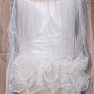 Detail of multi-layered white mesh ruffles and lace stitching on the luxury blouse sleeve
