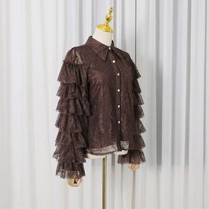 Detailed view of dark brown lace shirt featuring ruffled sleeves and white buttons