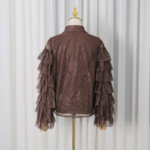 Detailed close-up of dark brown lace shirt with layered ruffle sleeves and rose floral patterns