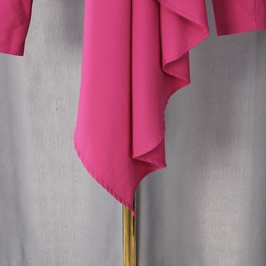 Close-up of elegant layered ruffle pleats on a rose red V-neck blouse with drape fabric