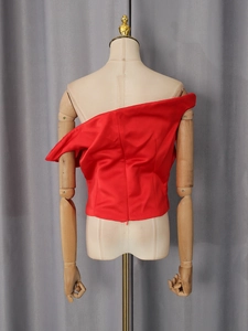 Dettaglio del retro di un top rosso monospalla con chiusura a cerniera lampo invisibile
