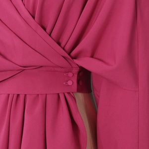 Detail of fuchsia wrap top featuring waist buttons and elegant side cut-out design
