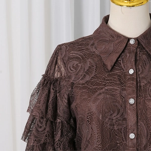Detail of dark brown lace shirt featuring rose jacquard patterns and ruffled sleeves