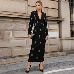 Close-up of elegant floral beadwork and high-quality fabric on black long skirt suit