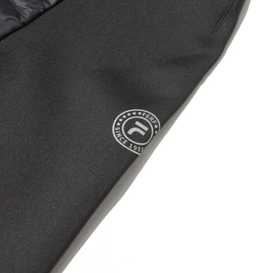 Detail shot of black down jacket sleeve featuring a round embroidered vintage F logo patch