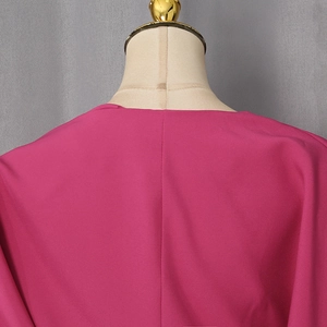 Close-up of the back seam and premium fabric texture of a slim-fit V-neck top in rose red