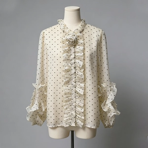 Detailed view of ruffle stand collar and rose flower accent on polka dot chiffon shirt