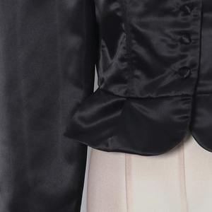 Detail of elegant black satin blouse featuring chic peplum hem and fabric-covered buttons
