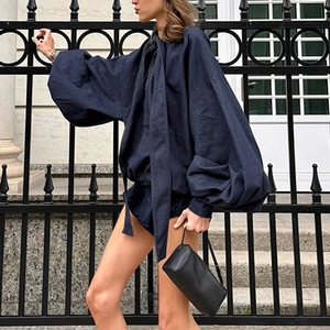 Detail of dark blue oversized shirt and shorts set with puff sleeves and tie collar texture