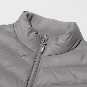 Detail of grey quilted jacket collar featuring warm fleece lining and sturdy zipper puller