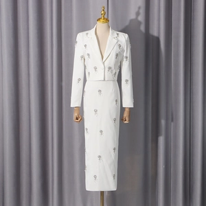 Detail view of white two-piece set featuring silver floral embroidery and sequins