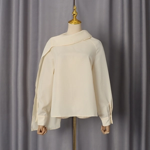 Detail view of off-white chiffon blouse featuring asymmetrical neckline and elegant side draping