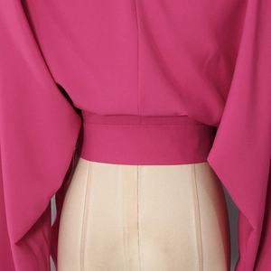 Detail of high waist belt and magenta purple fabric texture on the elegant V-neck top