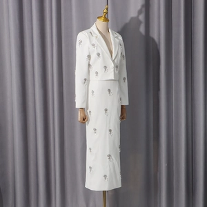 Detail of white two-piece set with elegant silver rhinestone floral embroidery texture