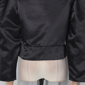 Detailed back view of a slim black satin blouse featuring puff sleeves and elastic hem
