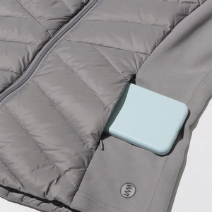 Detail of grey quilted jacket with hidden zipper pocket and circular silicone logo