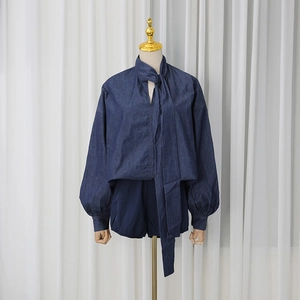 Detail of navy denim long sleeve blouse with tie-neck and matching loose shorts set