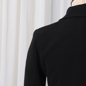 Detail of tailored shoulder seams and notched lapel on black slim fit blazer