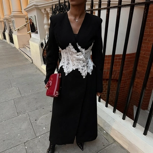 Détail d'un manteau noir long avec corset en dentelle blanche et col en V pour femmes