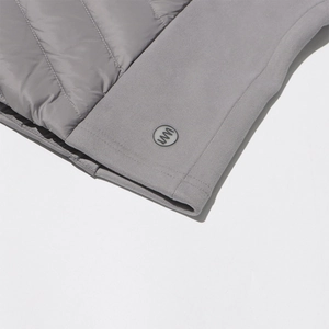 Detailed macro view of gray slim-fit down jacket with quilted windproof fabric and logo
