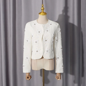 Detail of white blazer with 3D floral appliqués and pearl bead accents