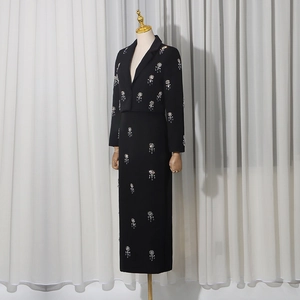 Detail of floral rhinestone embroidery on elegant black blazer and long skirt suit