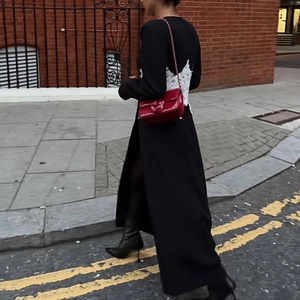 Détail d'un long manteau noir avec corsage en dentelle blanche au dos et look style de rue