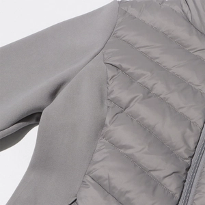 Detail shot of light grey mixed-fabric jacket showing fleece texture and quilted puffer stitching